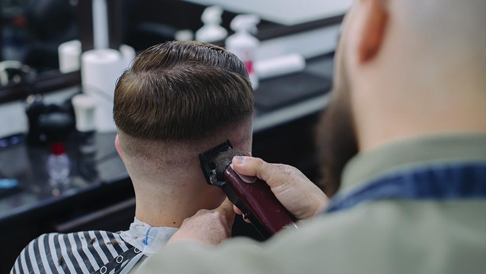  Peluquero hace el corte al cliente.